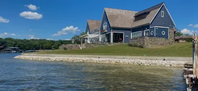 Rock shoreline protection below a blue lakefront home