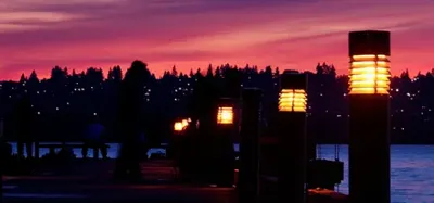 Illuminated dock posts at sunset