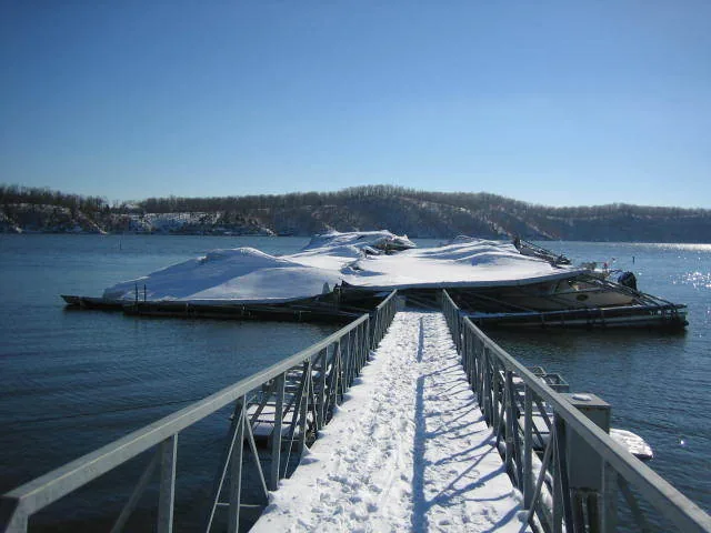 Snow piled on covered boat docks beside a walkway at Lake of the Ozarks.
